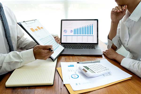 Two small business leaders discussing charts and graphs.
