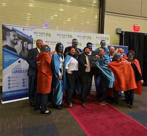 The Diamond team wearing capes and masks as they celebrate at the best places to work in PA awards. ceremony.