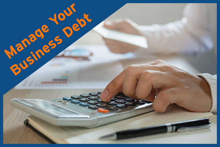 A person with a calculator trying to manage their business debt.