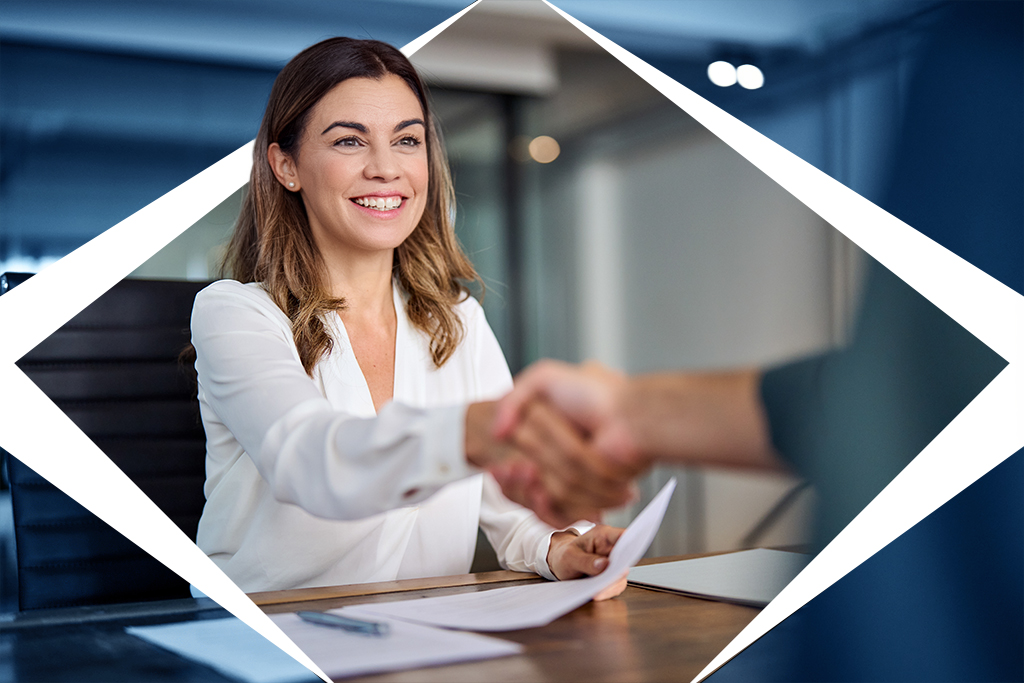 A woman is seen shaking the hand of someone that isn't in the photo. She represents becoming an employer and hiring someone.